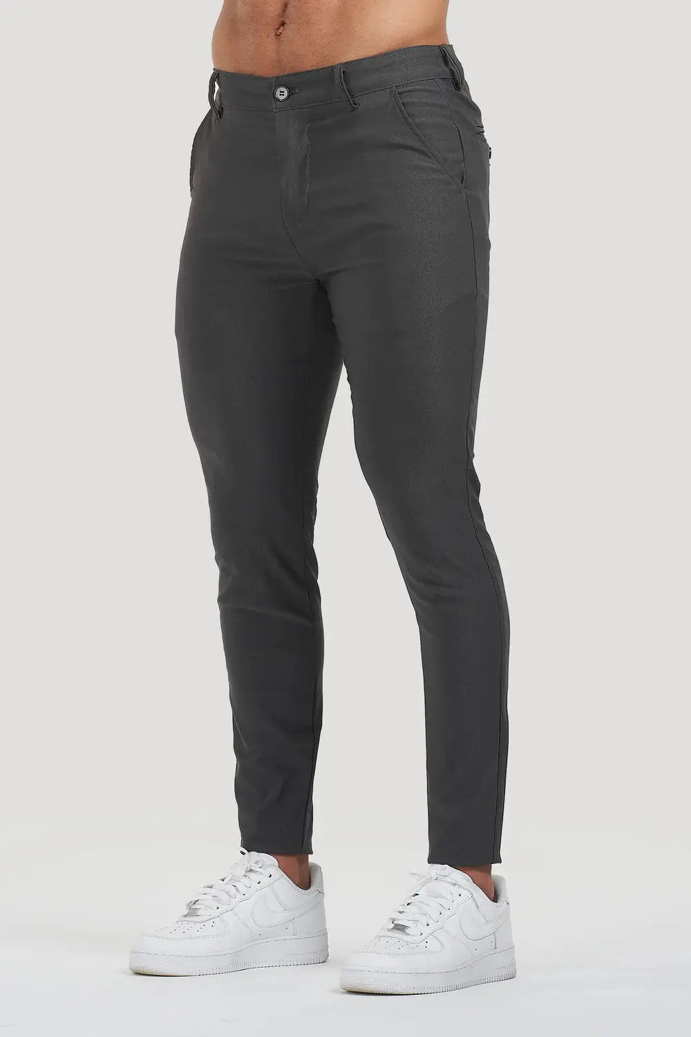 Avari slim fit dark grey trousers with tapered ankle, styled with white sneakers for a modern and versatile look.