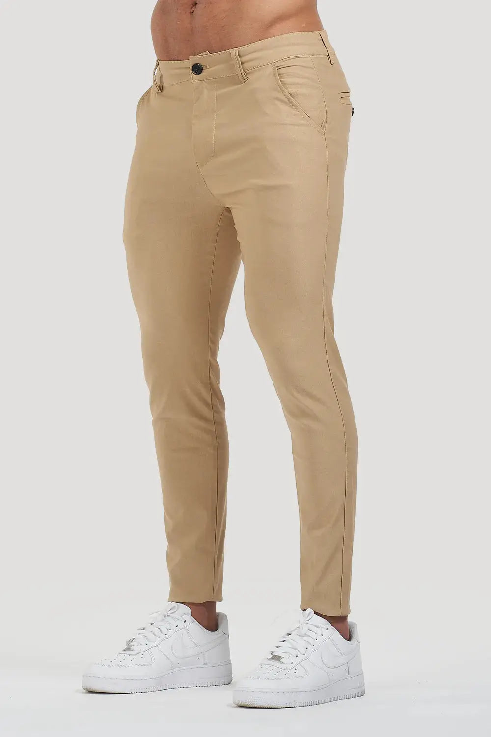 Avari Trousers Beige, slim-fit tapered design with front pockets, paired with white sneakers for a modern look.