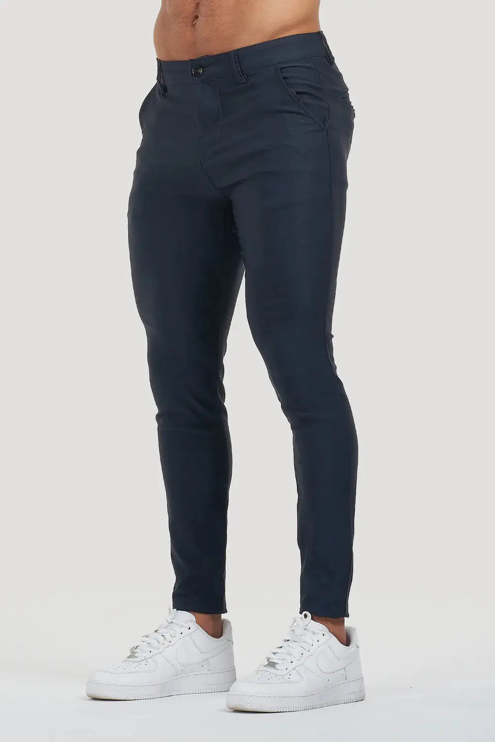 Avari Trousers Navy, slim-fit tapered design with front pockets, paired with white sneakers for a modern look.