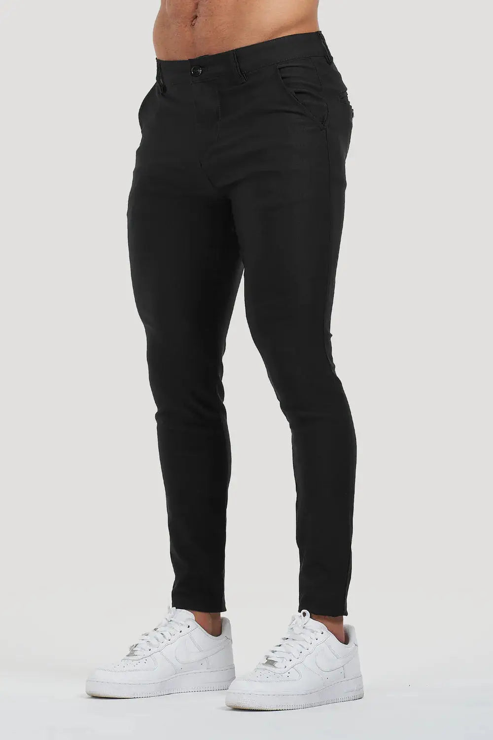 Avari Trousers in black slim fit, featuring a tapered ankle and paired with white sneakers for a sleek look.