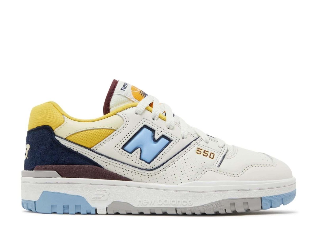 New Balance 550 Marquette sneakers featuring retro design, white leather upper with blue, yellow, and maroon accents, and slip-resistant sole.