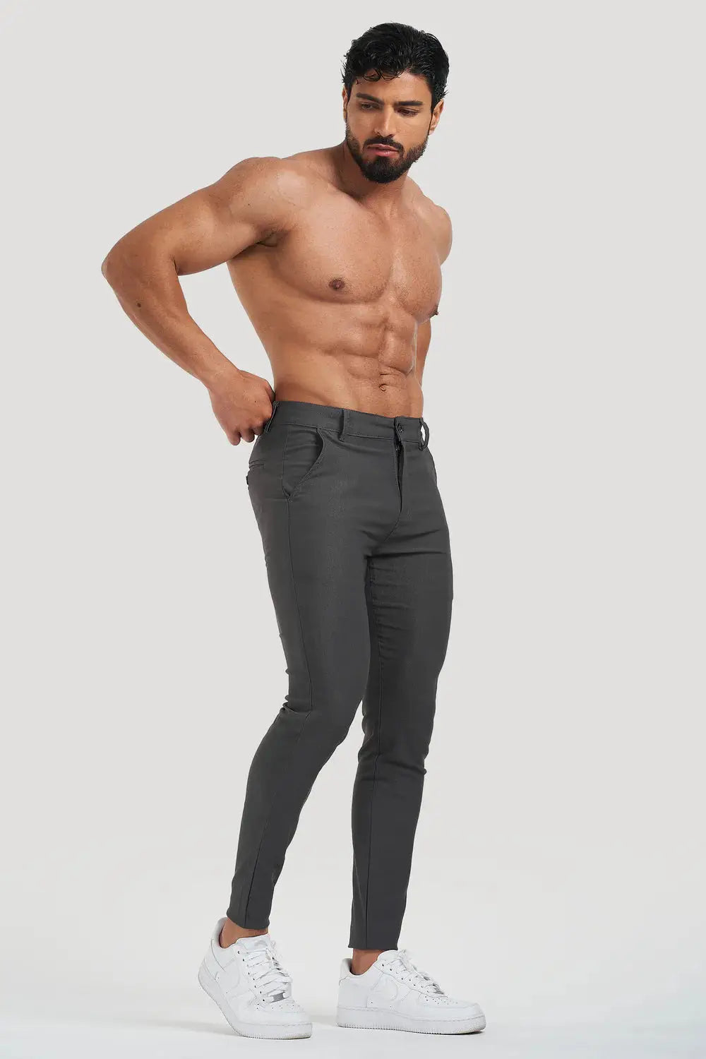 Model showcasing Avari slim fit grey trousers, emphasizing a tailored fit and flexibility, paired with casual white sneakers.