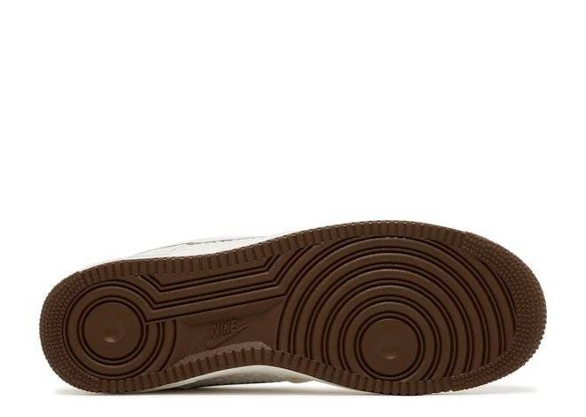 Outsole of Nike Air Force 1 07 SNKRS Day sneaker showing brown rubber sole with circular traction pattern for grip and durability.