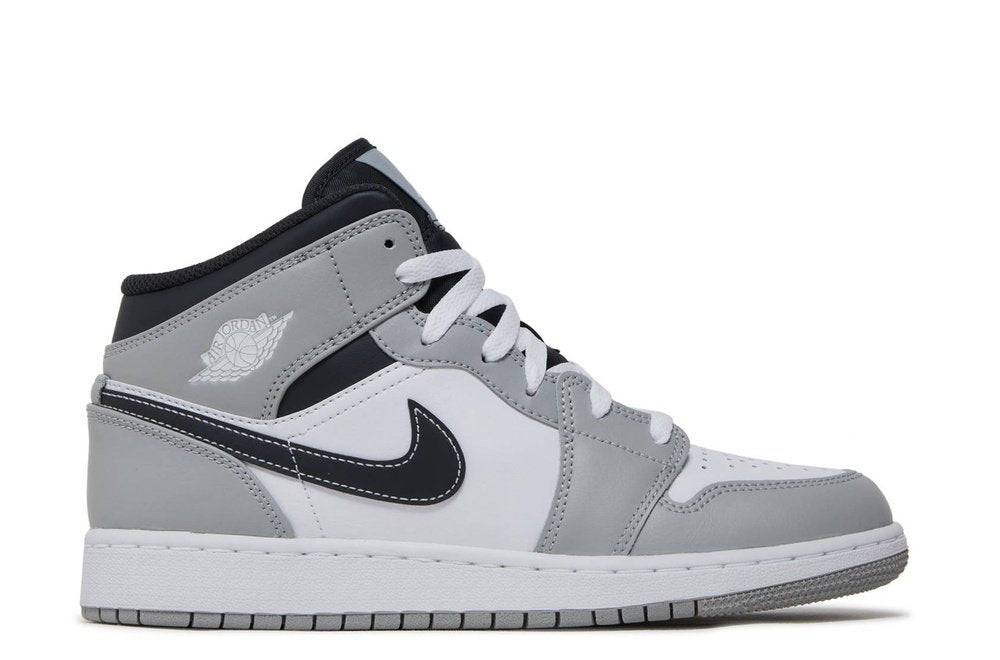 Air Jordan 1 Mid GS Light Smoke Grey sneaker in grade school sizes, featuring a white and black leather base with gray overlays and a classic Nike Swoosh.