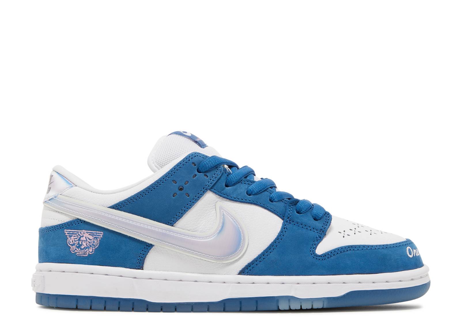 Born x Raised Dunk Low SB sneaker in white and blue with premium leather, silver Swoosh, and 'One Block at a Time' design on toe.