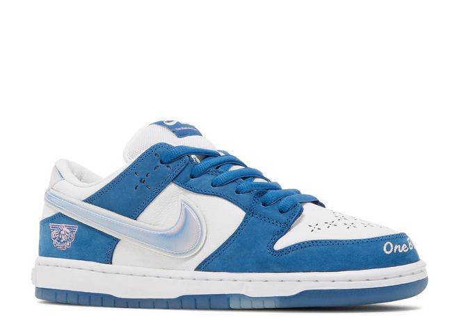 Side view of Born x Raised Dunk Low SB sneaker showcasing blue suede overlays, silver Swoosh, and intricate LA-inspired details.