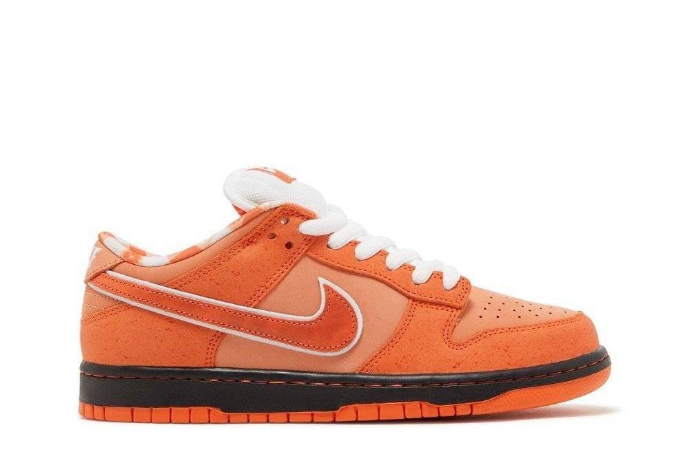 Concepts x Dunk Low SB Orange Lobster sneaker with orange suede overlays, white laces, and a black midsole. Features Nike Swoosh and bib-pattern lining.