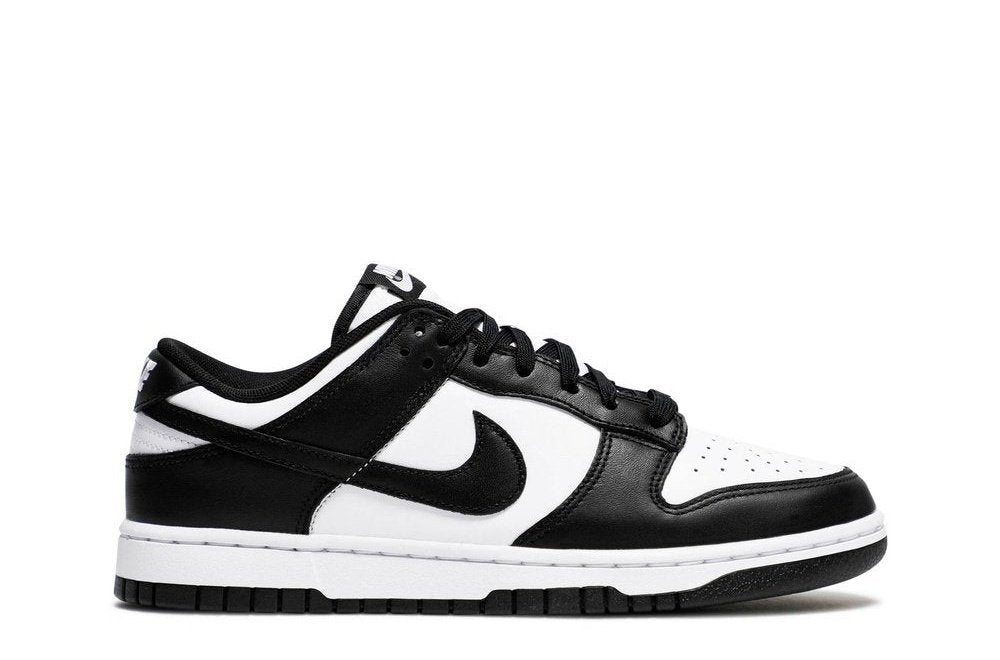 Nike Dunk Low Black White sneaker showcasing a side profile with white leather base and black overlays, featuring the iconic Swoosh logo.