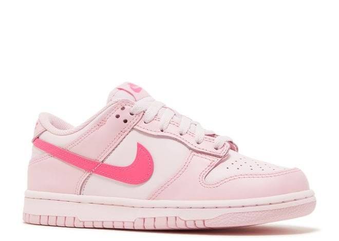 Nike Dunk Low GS Triple Pink sneaker showcasing light pink leather upper with vibrant pink Swoosh, angled side view. Perfect for casual wear.