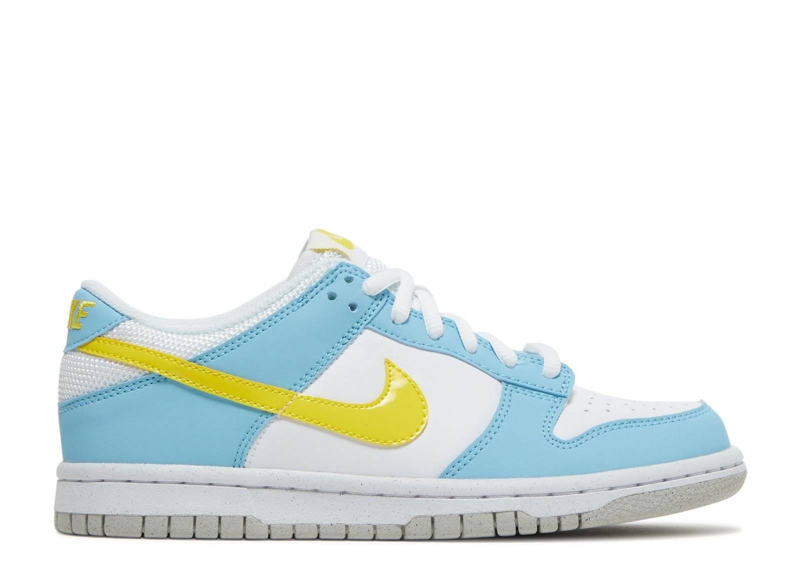 Nike Dunk Low Next Nature GS Homer sneaker featuring a white leather upper, light blue overlays, and a yellow Swoosh, designed with eco-friendly materials.