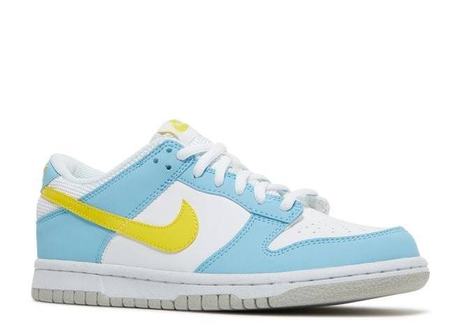 Side view of the Nike Dunk Low Next Nature GS Homer sneaker showcasing its light blue overlays, yellow Swoosh, and white leather base with sustainable design.