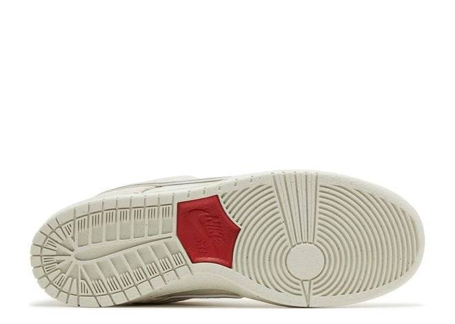 Outsole of Nike Dunk Low City of Love sneaker featuring a light bone rubber sole with a university red Nike SB logo detail.