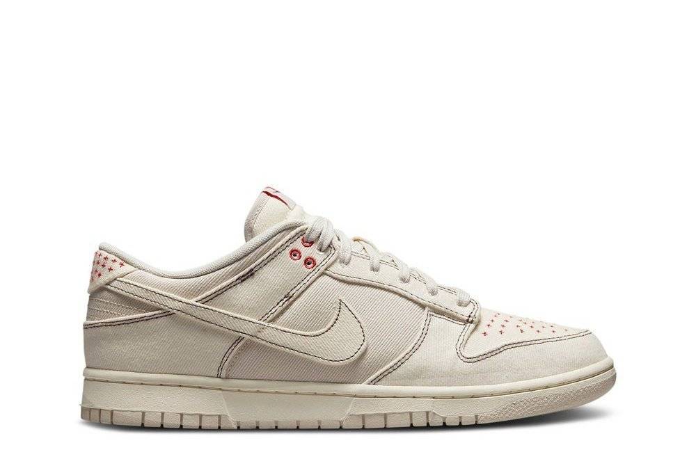 Nike Dunk Low Sashiko sneaker in Light Orewood Brown with pale ivory denim upper, Orewood Brown stitching, and red Sashiko embroidery details.