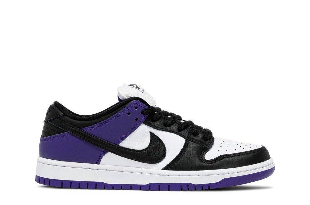 Nike Dunk Low SB Court Purple sneaker with a white leather upper, black overlays, and purple heel detailing. Classic skateboarding shoe design.