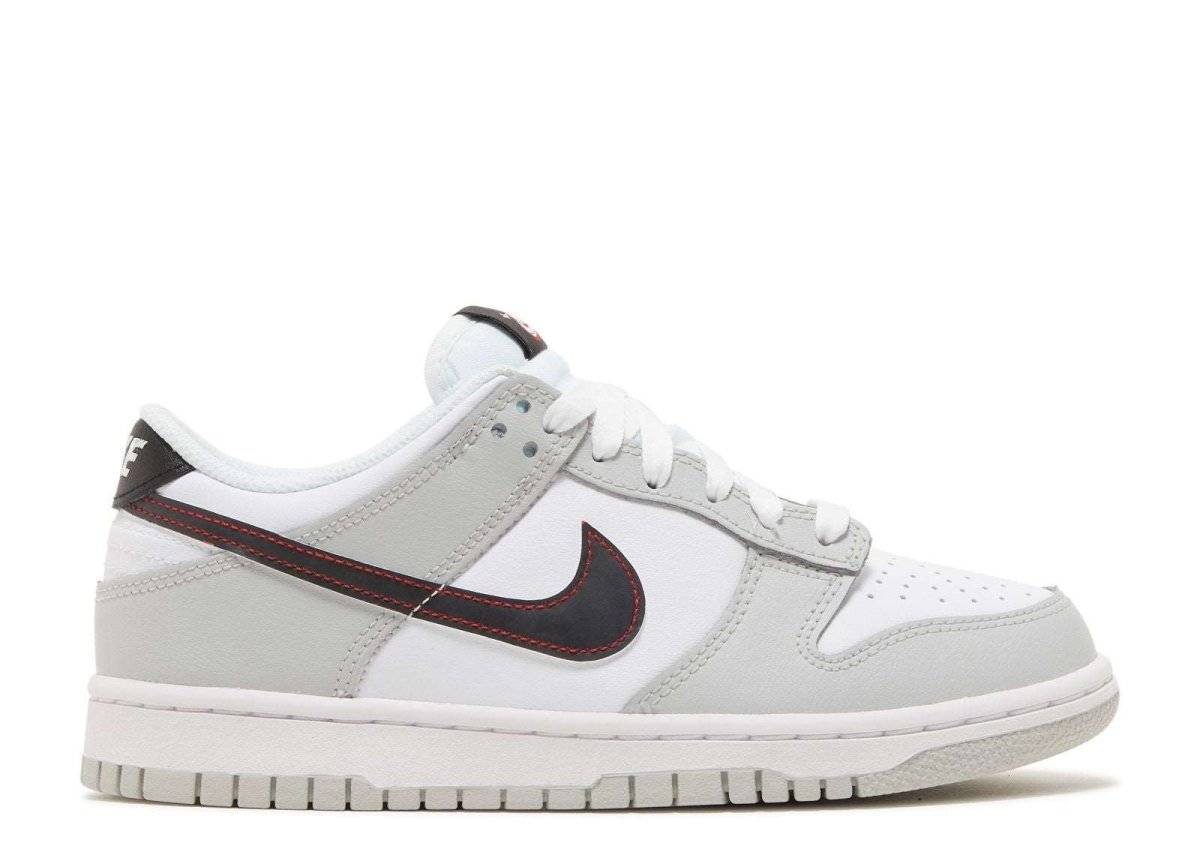 Nike Dunk Low SE GS Lottery Pack in grey fog with leather upper, black Swoosh, and white midsole. Neutral tones for versatile styling.