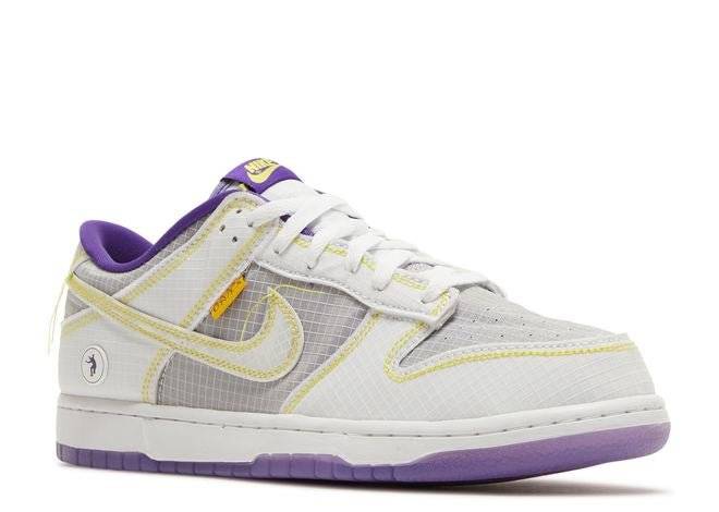 Nike Dunk Low Union LA Court Purple sneaker with white and purple colorway, yellow stitching, and signature tear-away ripstop design.