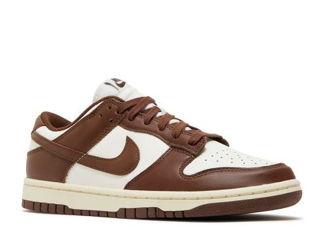 Side angle view of Nike Wmns Dunk Low Cacao Wow sneakers showcasing brown leather overlays, white base, and classic lace-up closure.