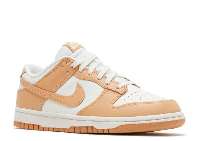 Side angle view of Nike Dunk Low Harvest Moon sneaker showcasing white leather upper, brown overlays, and perforated toe box for breathability.