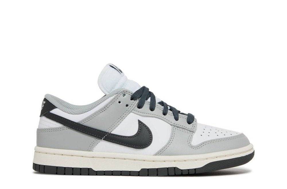 Wmns Dunk Low Light Smoke Grey sneaker in leather with a white base, light smoke grey overlays, and black Nike Swoosh. Iconic low-top design.