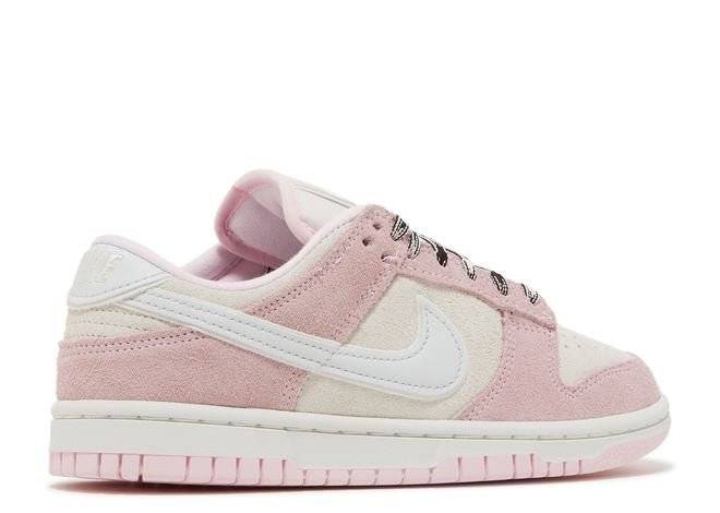 Rear angle of Nike Wmns Dunk Low LX Pink Foam sneaker showcasing pink suede, white leather, and embroidered Nike branding.