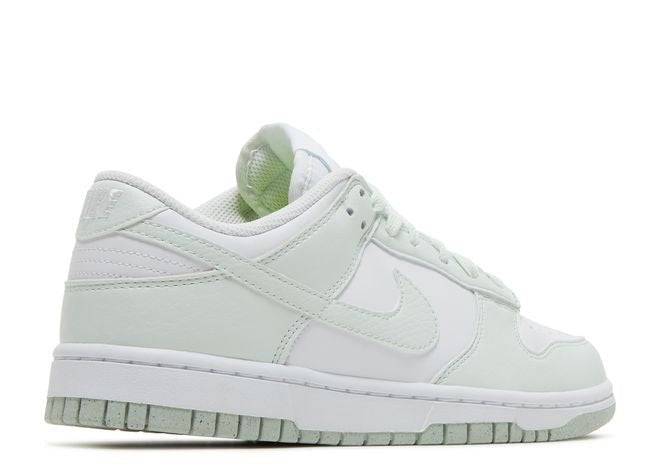 Side view of the Wmns Dunk Low Next Nature sneaker in white and mint green, highlighting its sustainable materials and sleek design.