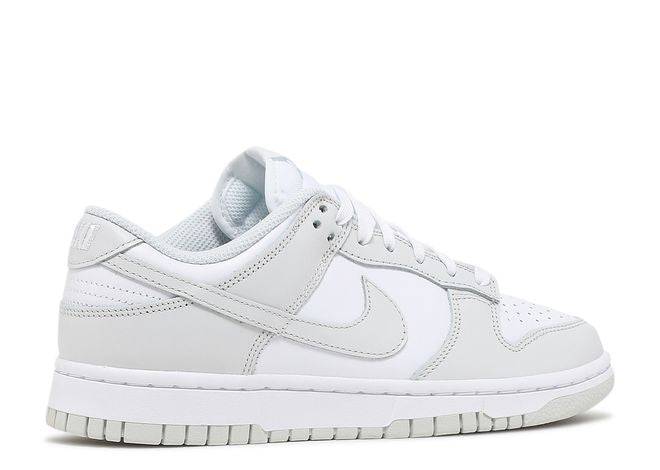 Side view of Wmns Dunk Low Photon Dust sneaker with a minimalist white and gray colorway, durable sole, and iconic Nike logo.