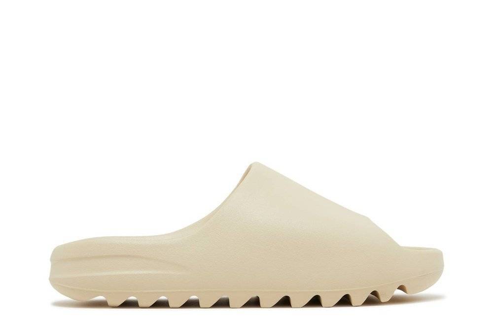 Yeezy Slides Bone 2022 restock featuring a minimalist design in beige with a pebbled texture, grooved sole, and cushioned footbed.