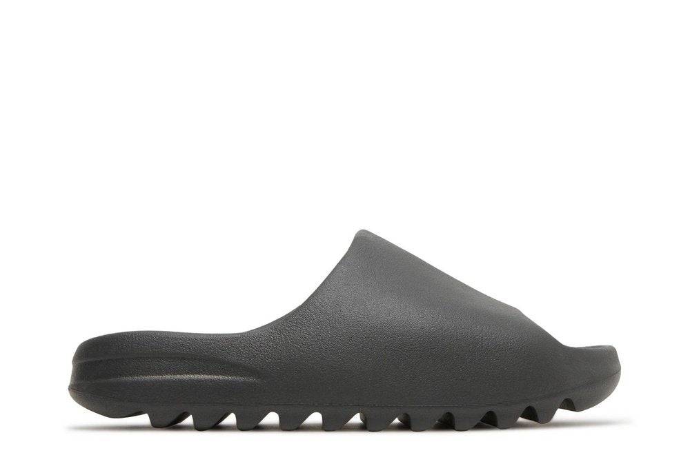 Yeezy Slides Onyx in dark minimalist design, featuring a sleek silhouette and ridged sole for stylish comfort. Perfect for casual and versatile wear.