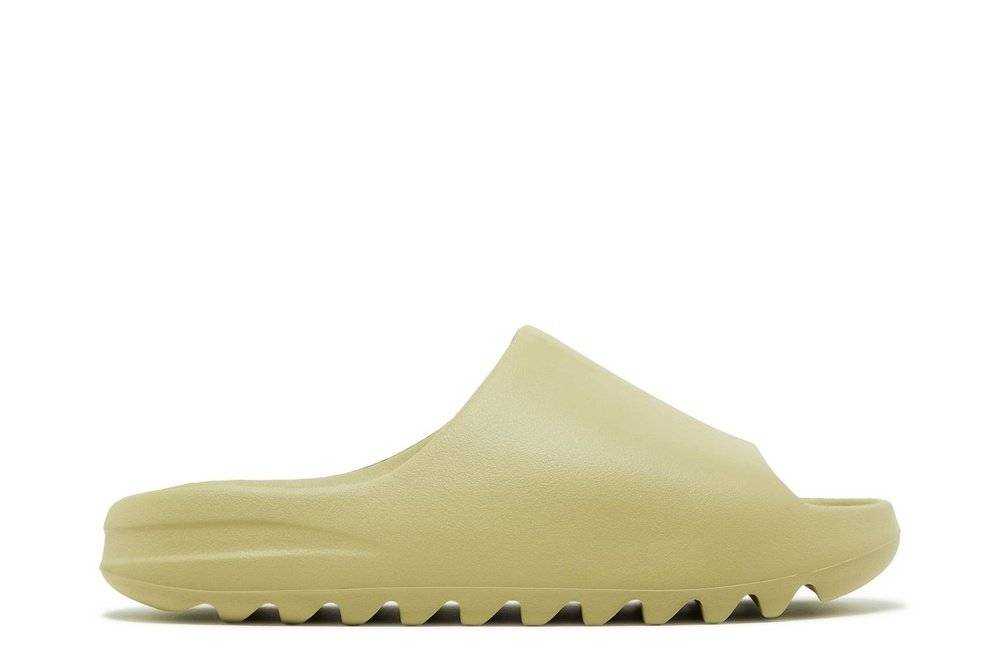 Yeezy Slides Resin 2022 in pale green EVA foam, featuring a minimalist one-piece design and sawtooth outsole for enhanced grip.